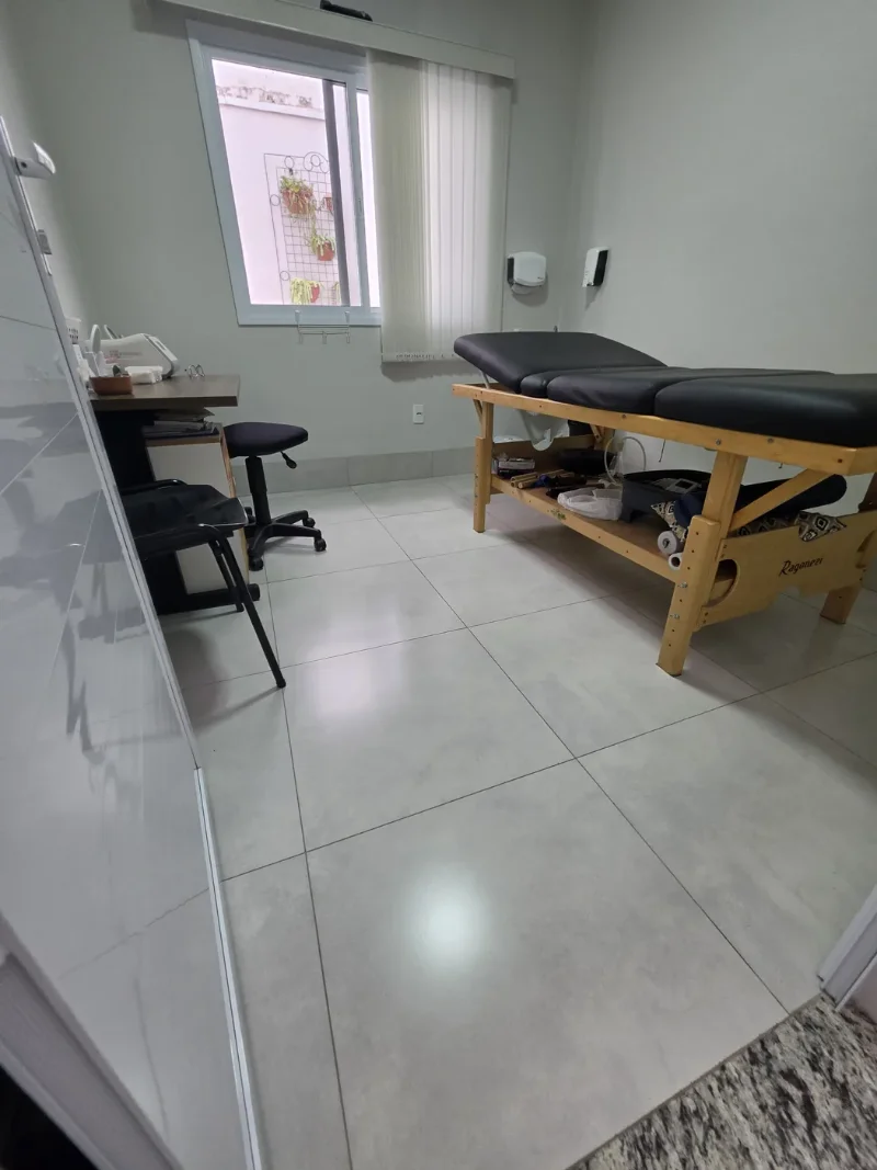 Sala de atendimento de ozonioterapia com maca e mesa de apoio