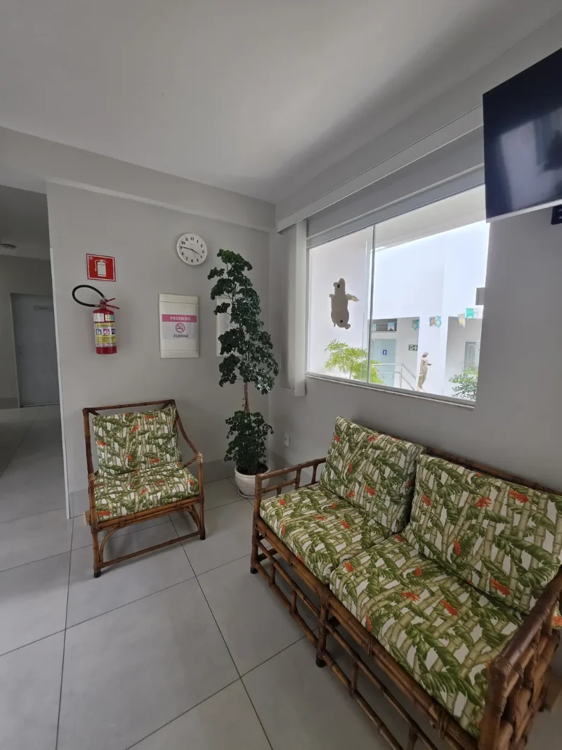 Sala de espera com poltronas de fibra natural e plantas